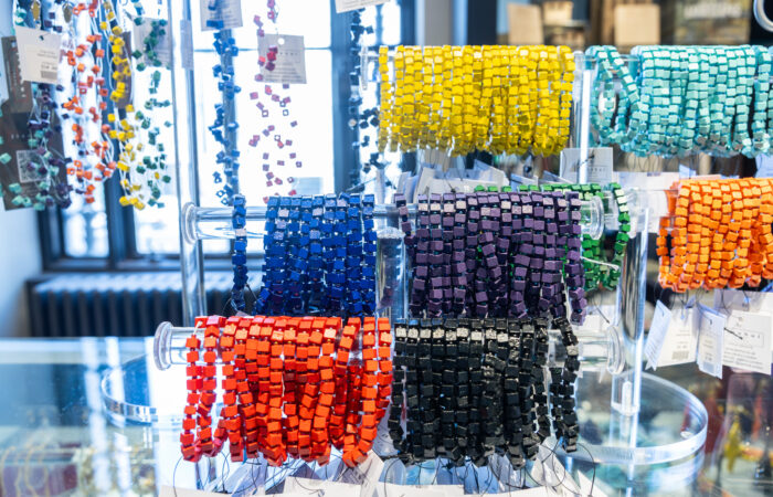 Rainbow beaded bracelets on a glass display case.