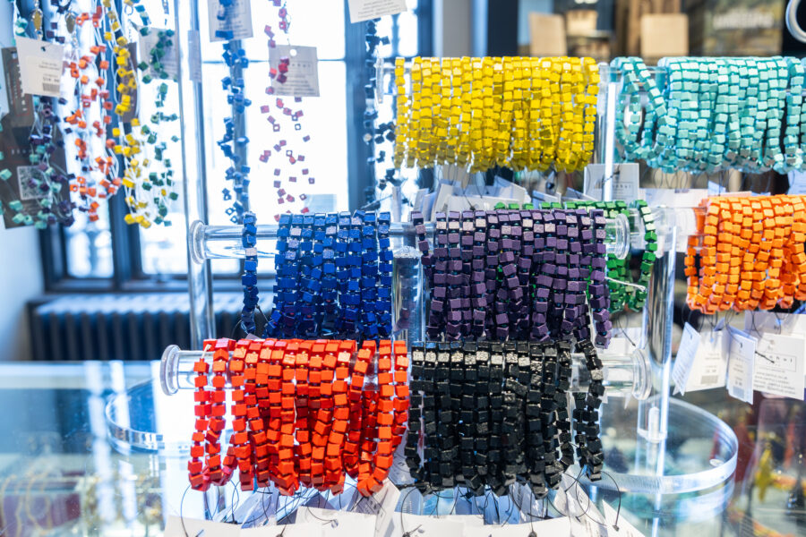 Rainbow beaded bracelets on a glass display case.