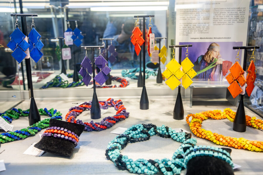 Rainbow colored jewelry displayed in a glass case.
