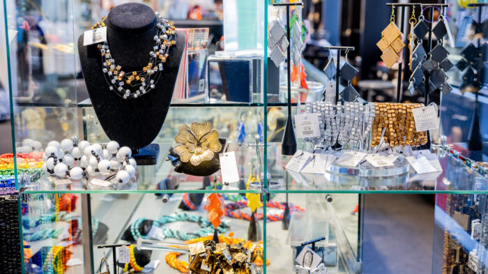 Glass display case with a variety of unique, beaded jewelry.