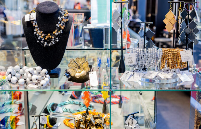 Glass display case with a variety of unique, beaded jewelry.