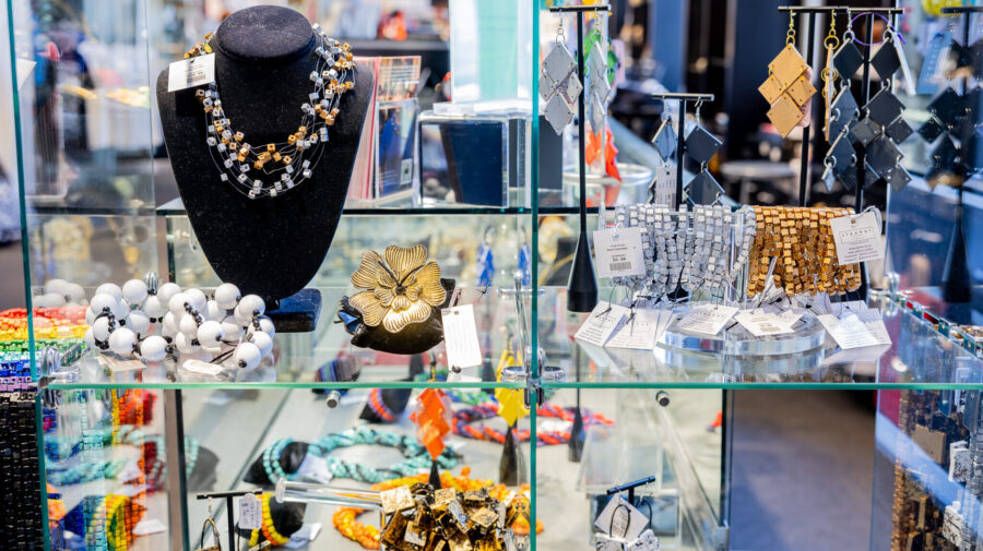 Glass display case with a variety of unique, beaded jewelry.