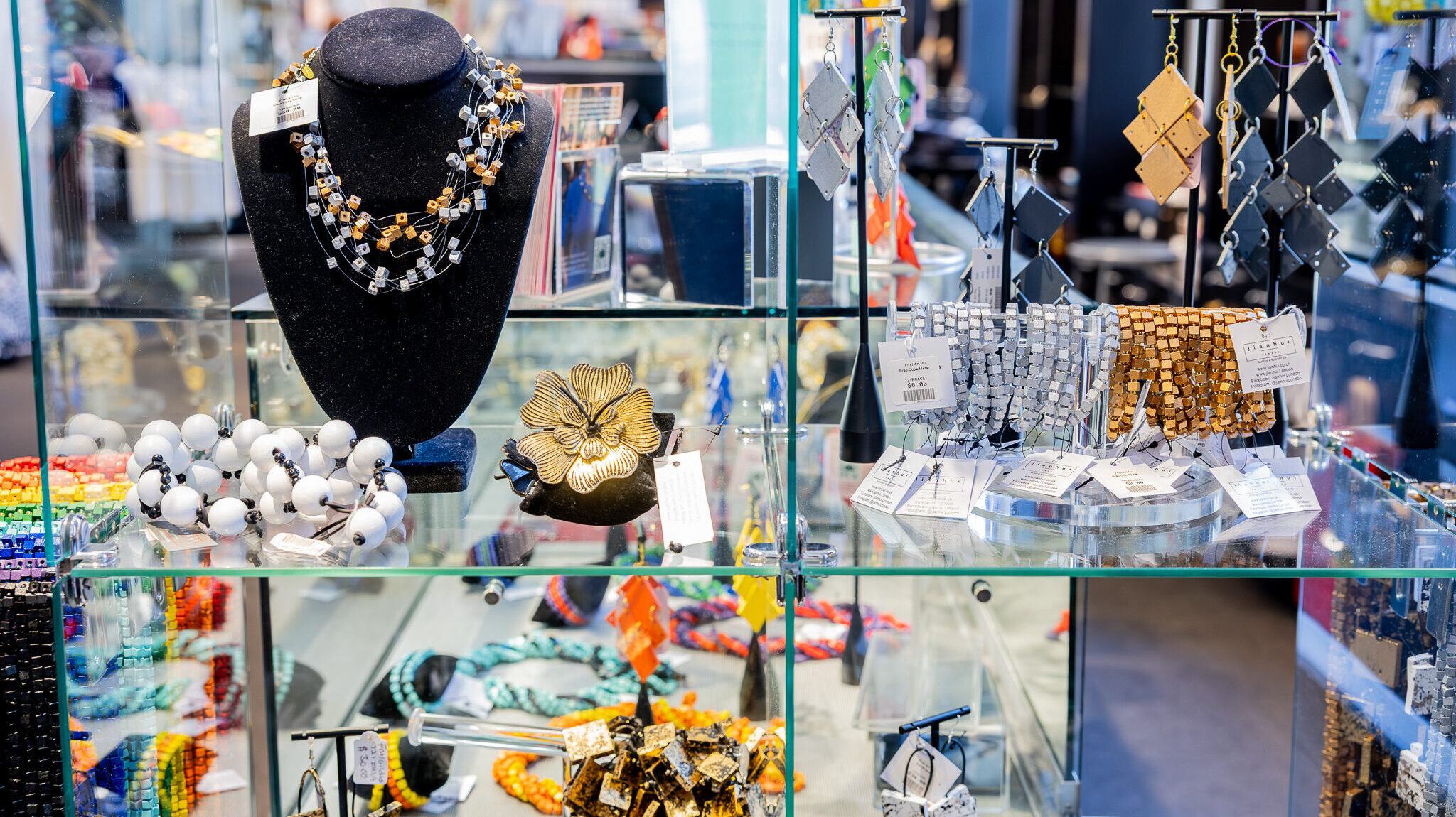 Glass display case with a variety of unique, beaded jewelry.