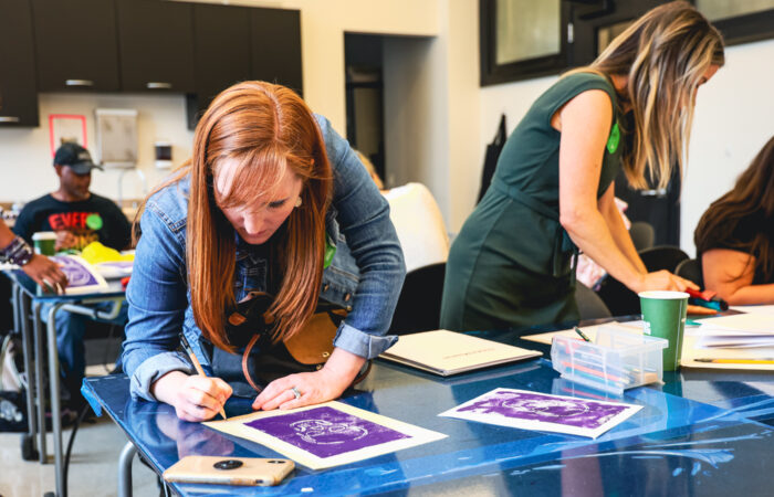 Two women create prints in a printmaking workshop.