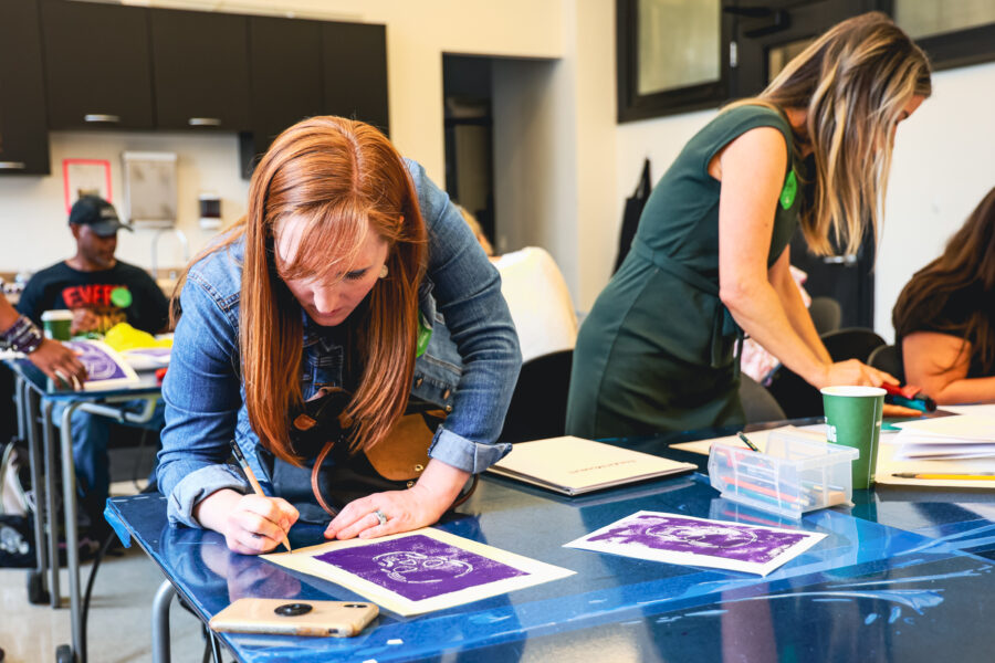 Two women create prints in a printmaking workshop.