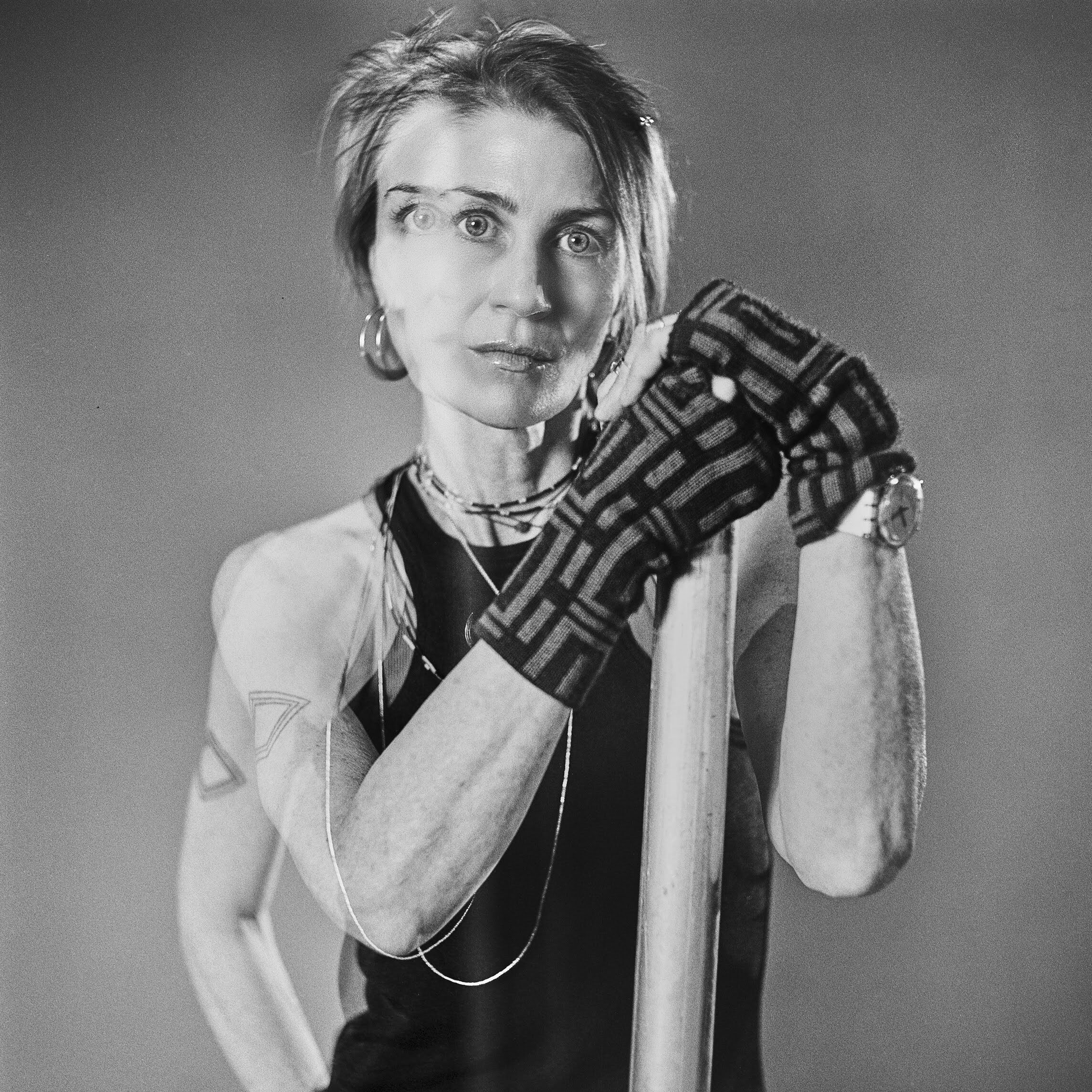 A woman poses with a post where the image is overlayed with another image. 