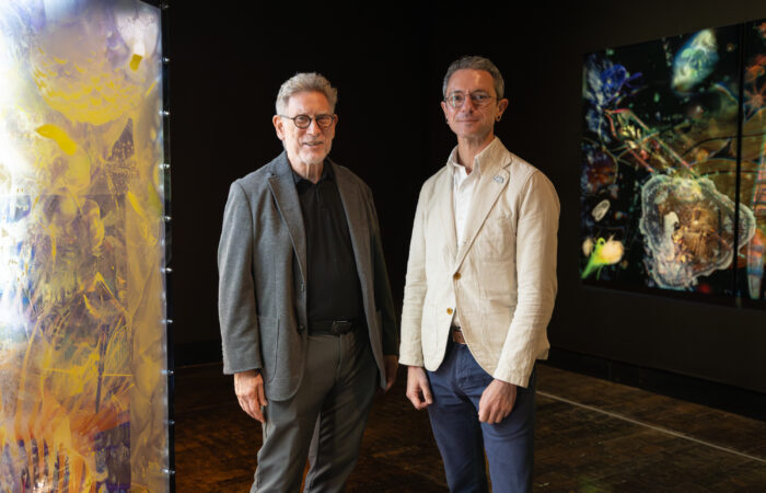 Mark Scala and Seth Feman stand next to each other in an art gallery.
