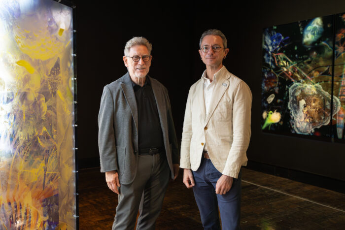 Mark Scala and Seth Feman stand next to each other in an art gallery.