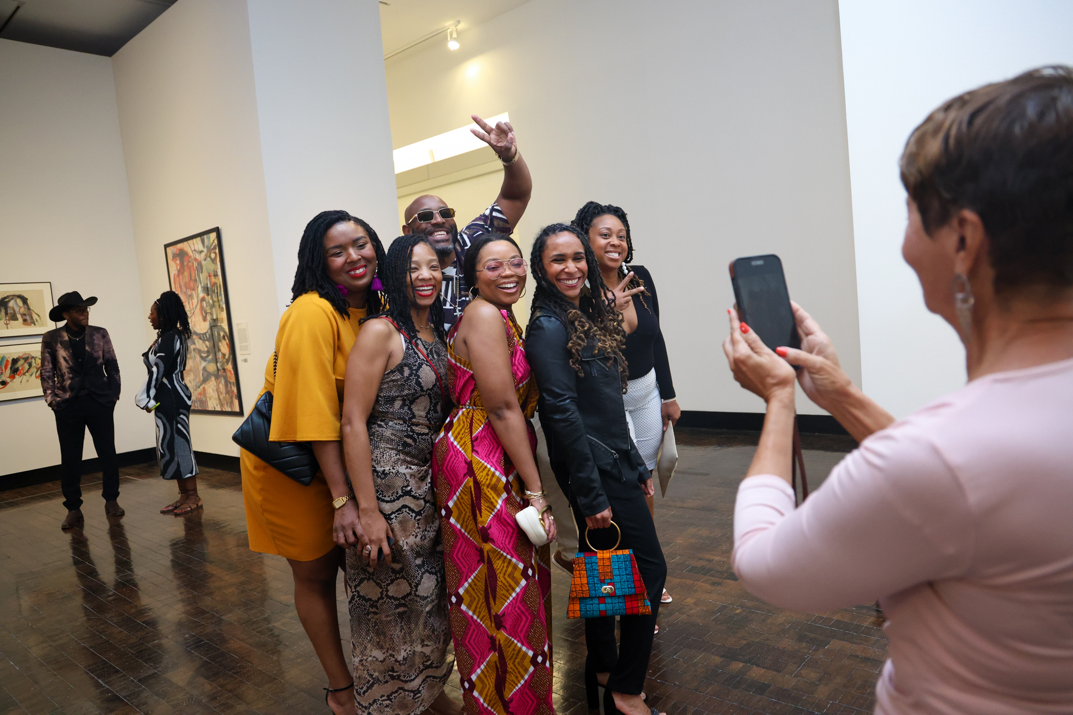 Group of adults posing for a photo in a gallery