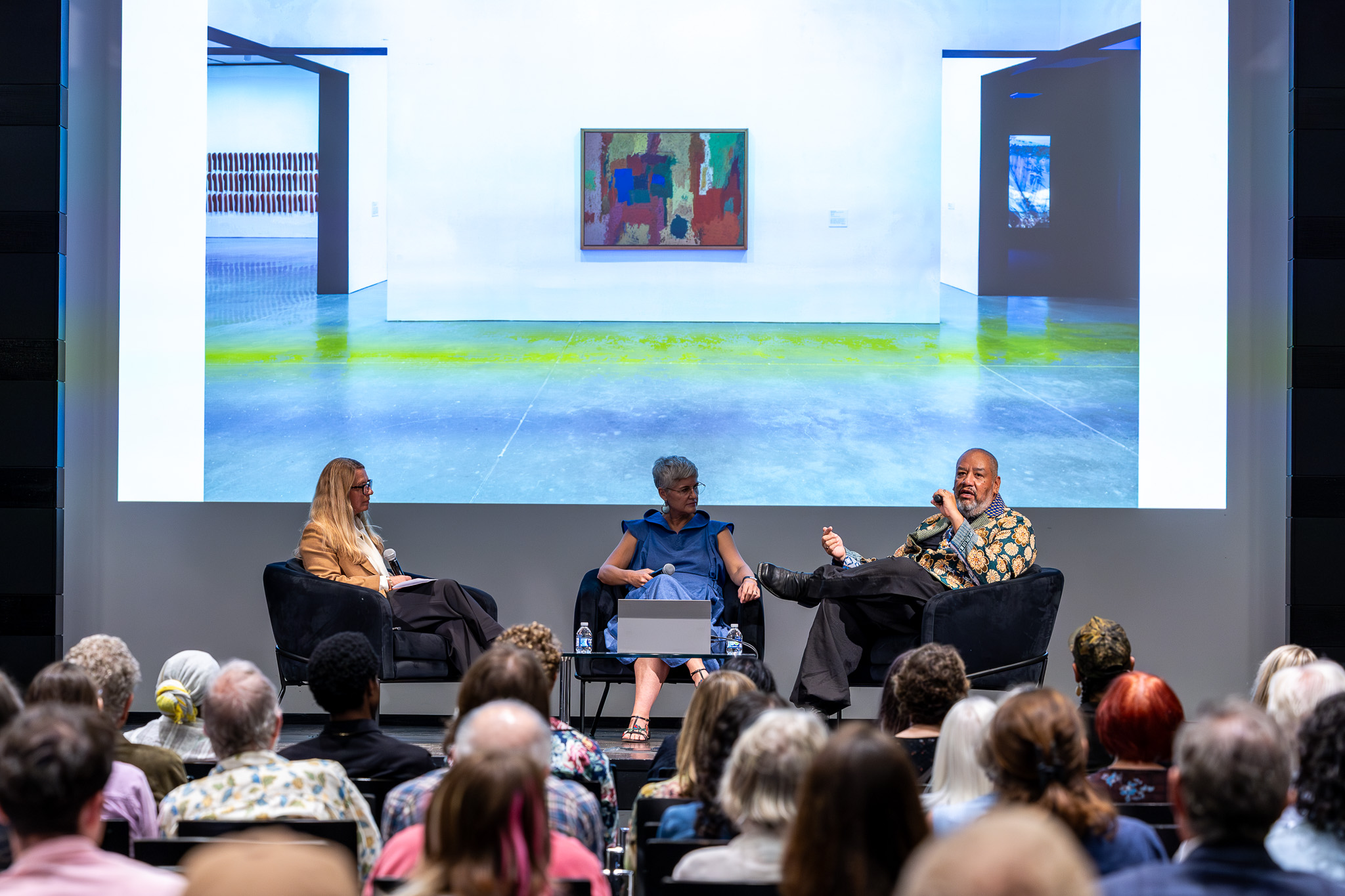 Three people on stage talking to an audience