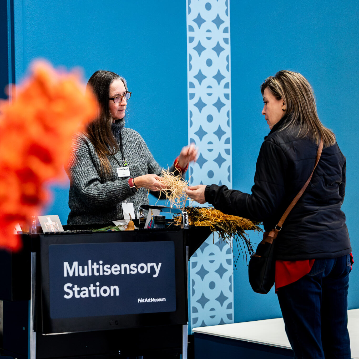 Two woman look at some textured string at a Multisensory Station.