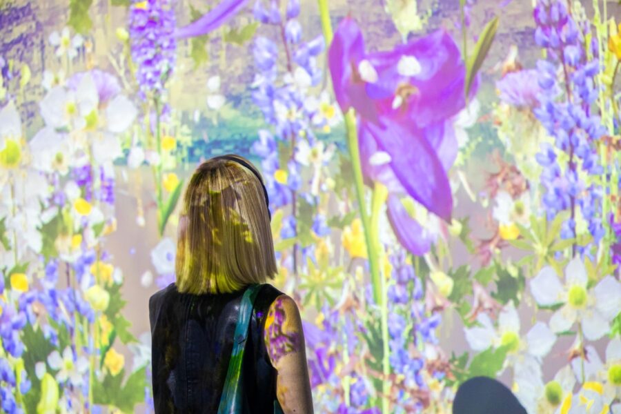 Woman looking at a colorful flower projection