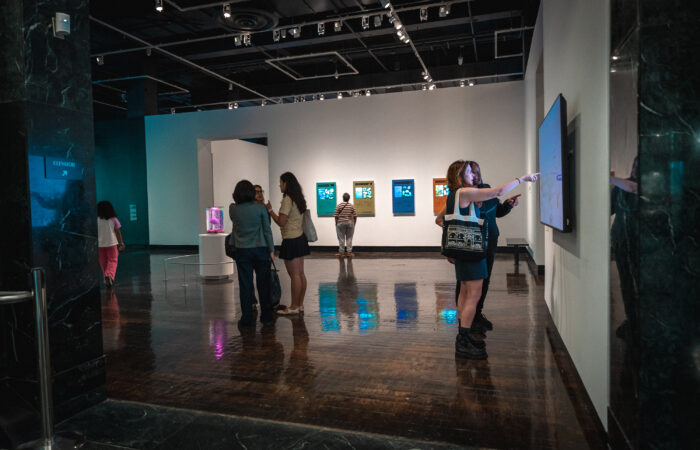 People walk around an art gallery with digital and futuristic art.