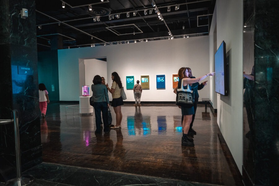 People walk around an art gallery with digital and futuristic art.