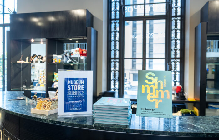 A display of a book and a poster for an event in a museum gift shop.