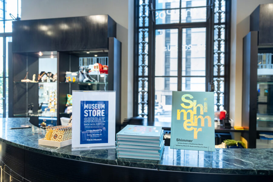 A display of a book and a poster for an event in a museum gift shop.