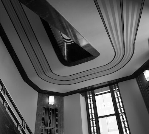 black and white photograph taken under one of the staircases at the Frist showing art deco details and lines