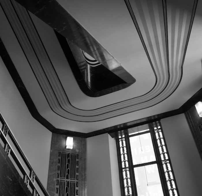 black and white photograph taken under one of the staircases at the Frist showing art deco details and lines