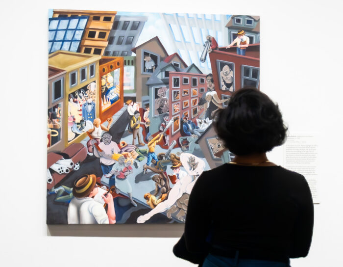 The back of a woman looking at a painting