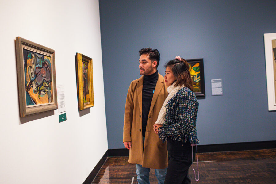 Young couple looking at paintings on a wall