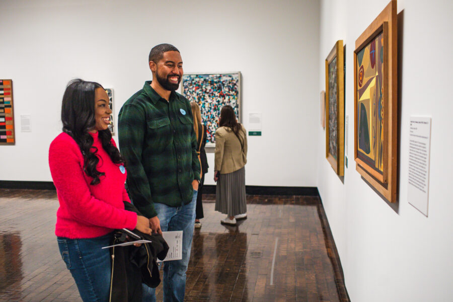 Couple looking at a painting in a gallery and smiling