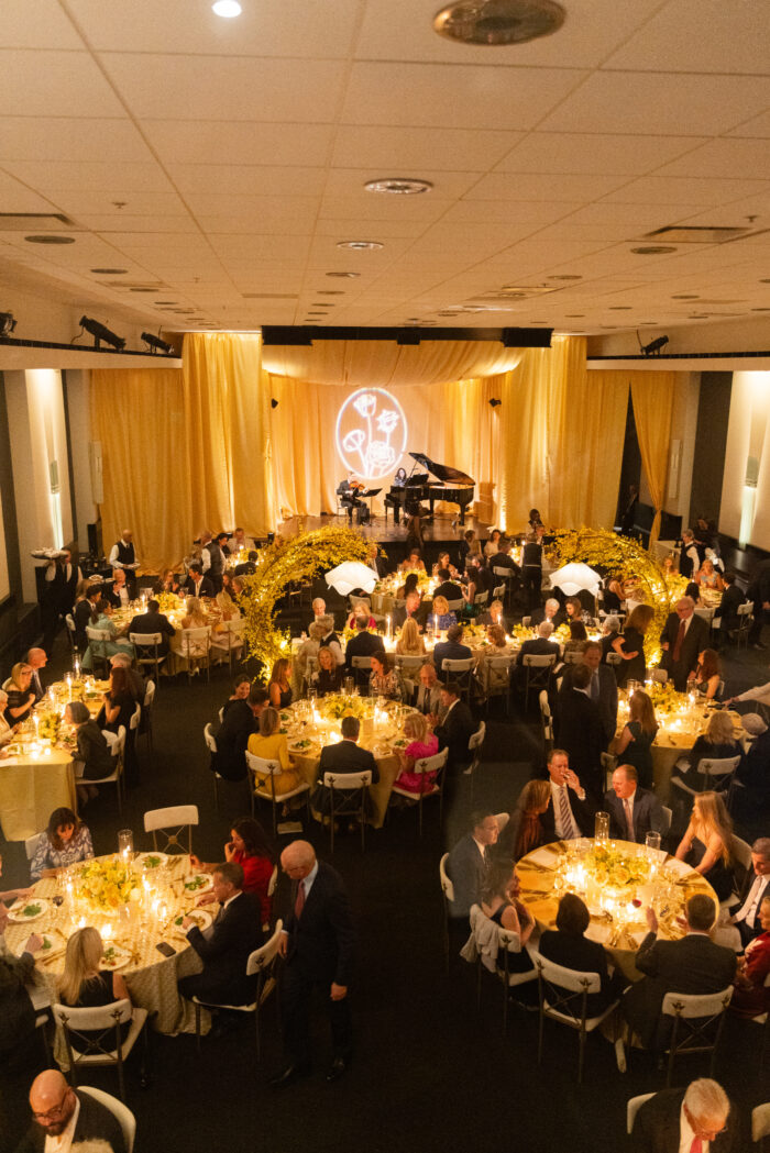 Overhead view of people gathered around decorated tables and fabric draped from the ceiling. 