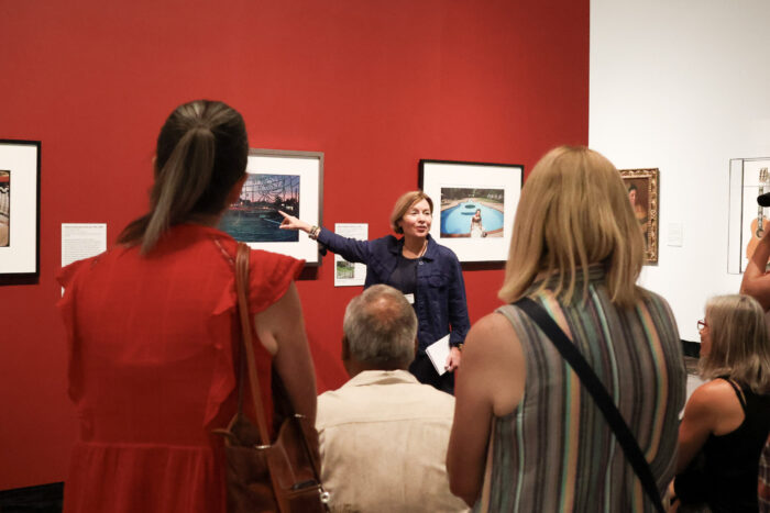 Docent pointing to a photograph during a tour of the Storied Strings gallery