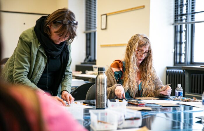Two women at a table working on an art project