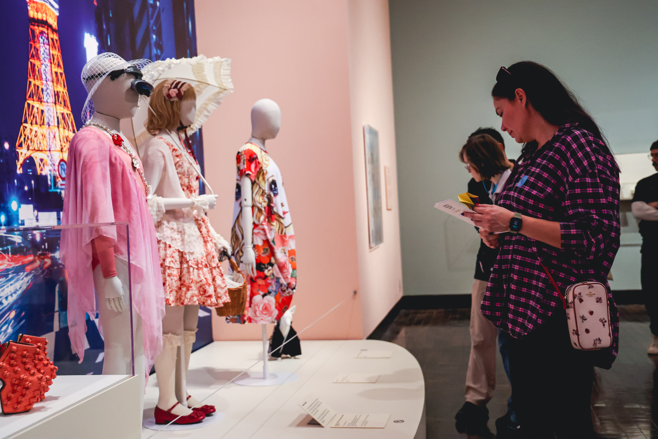 A woman is looking at mannequins dressed in Japanese fashion