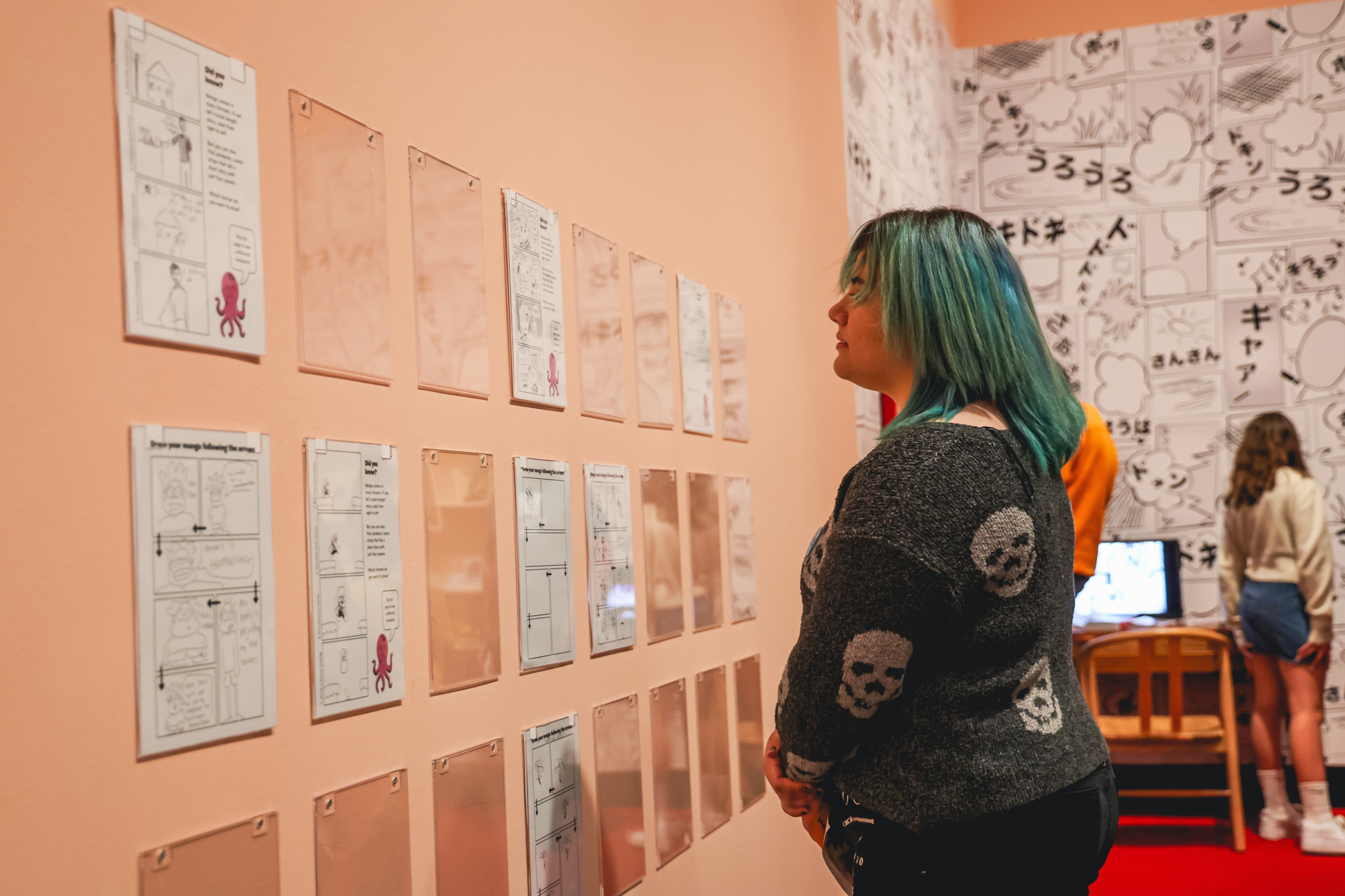 Woman looking at a wall with Manga drawings