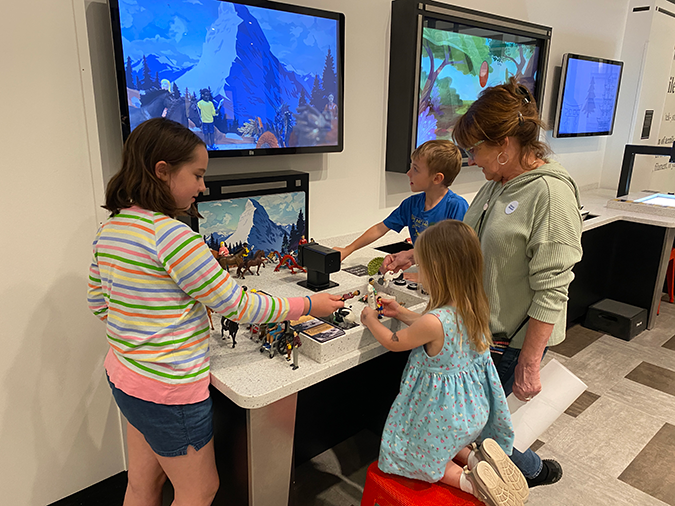 Mom and three children interacting with the animation station in ArtQuest
