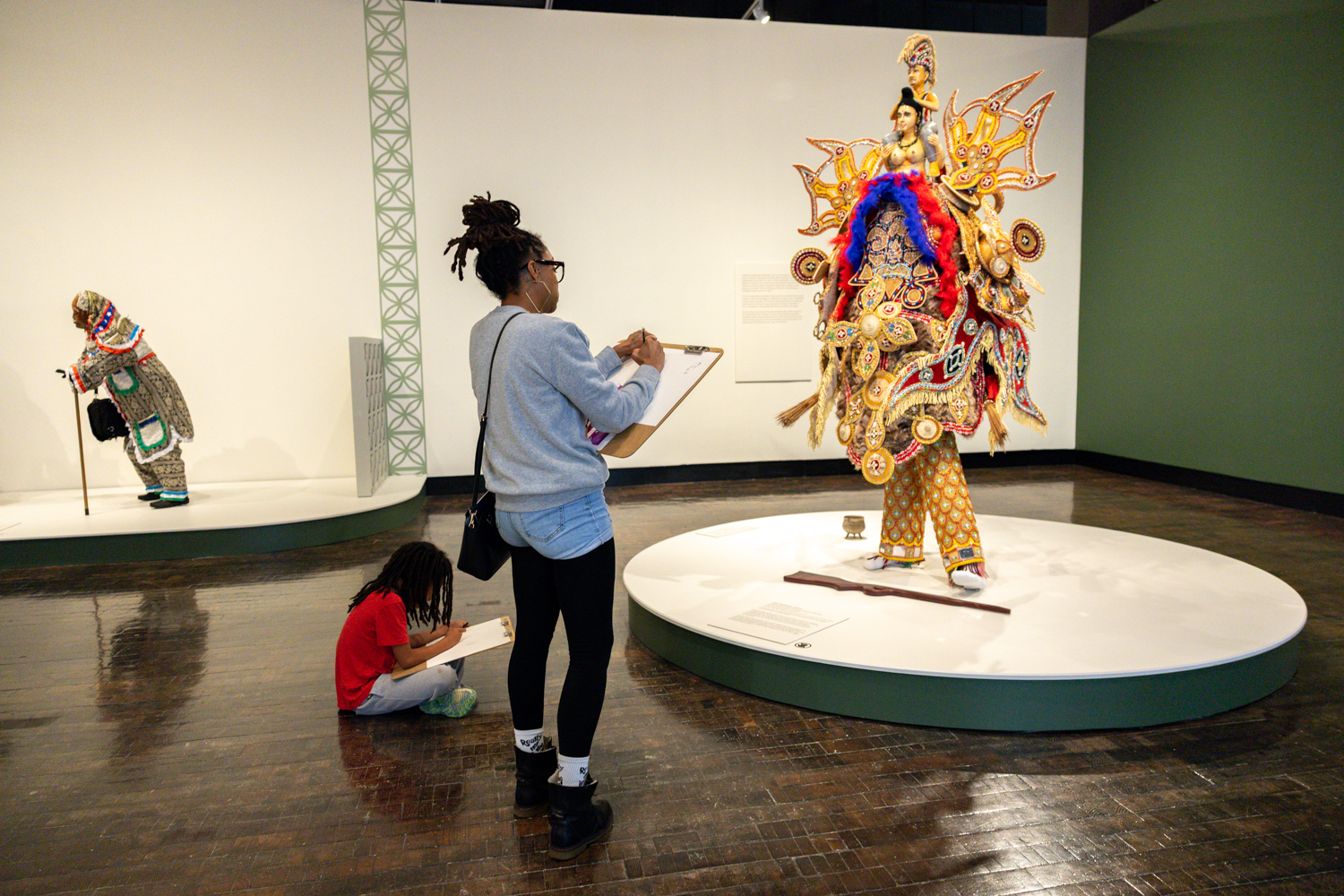 A mom and child draw together in an art gallery.