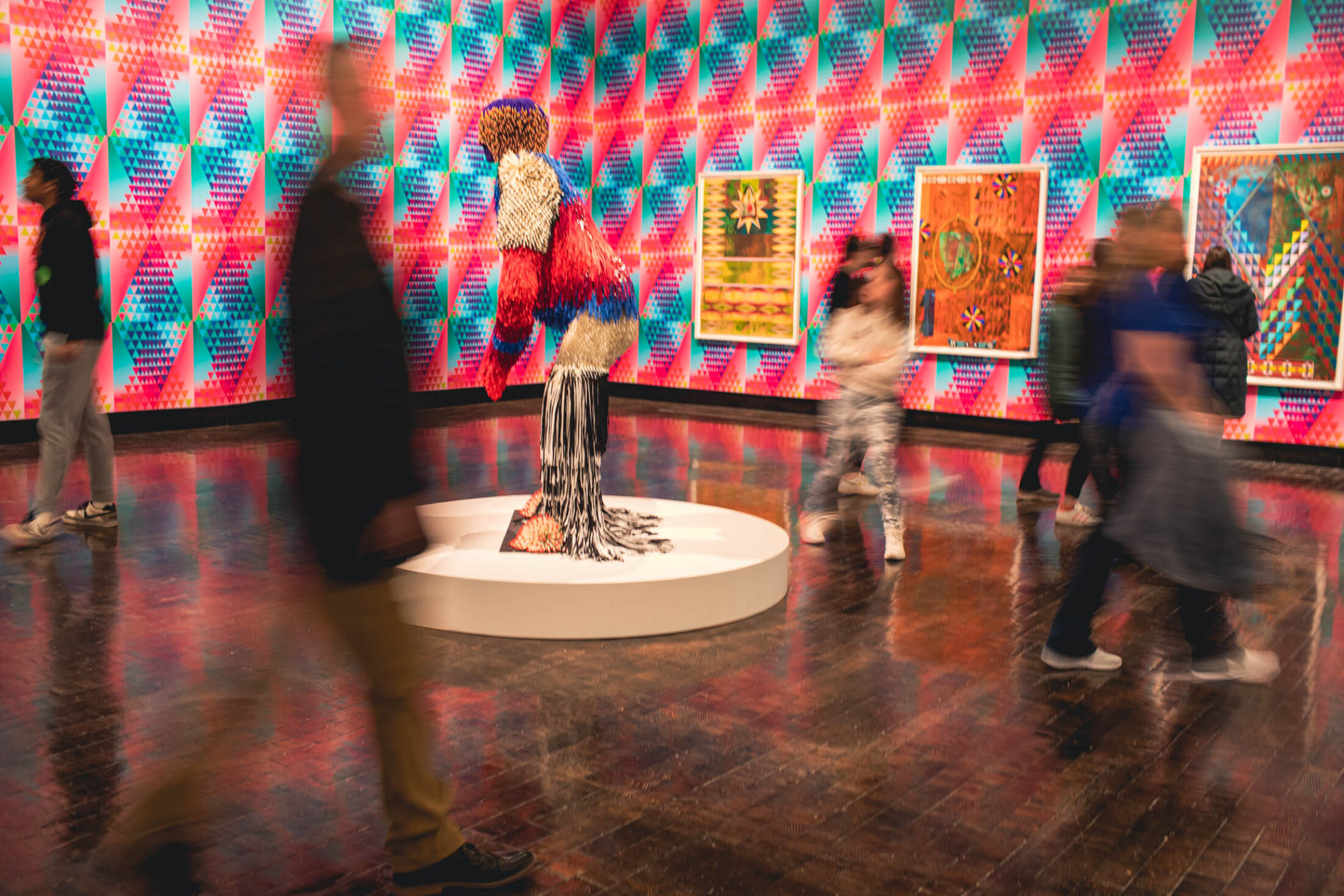 Blurred people walking through a very colorful gallery