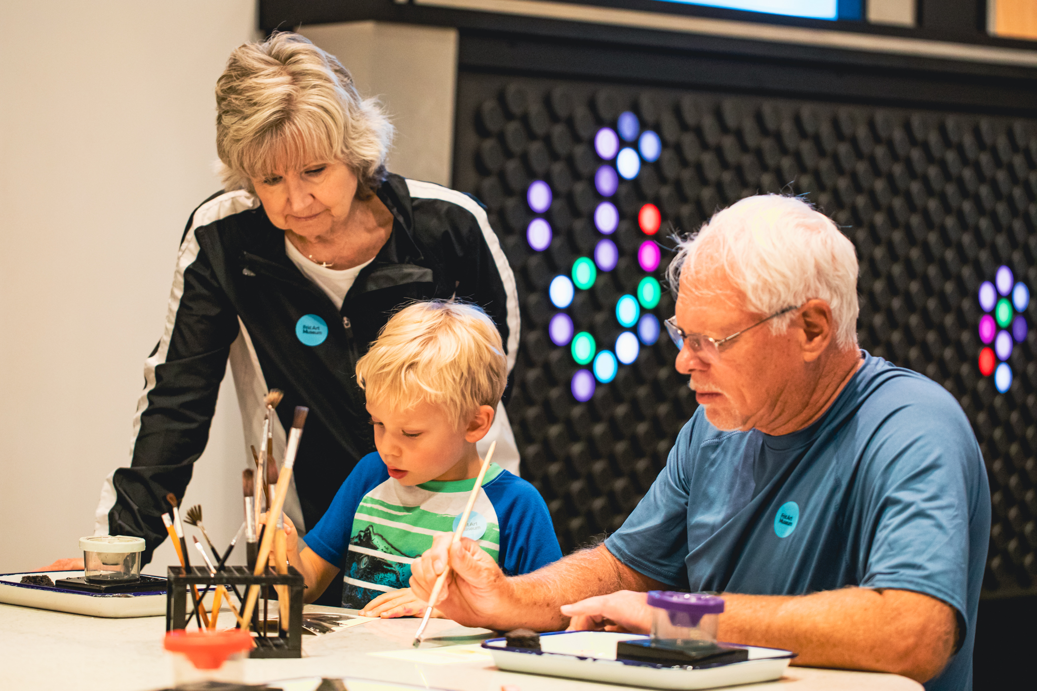 Grandparents and their grandson painting at a table