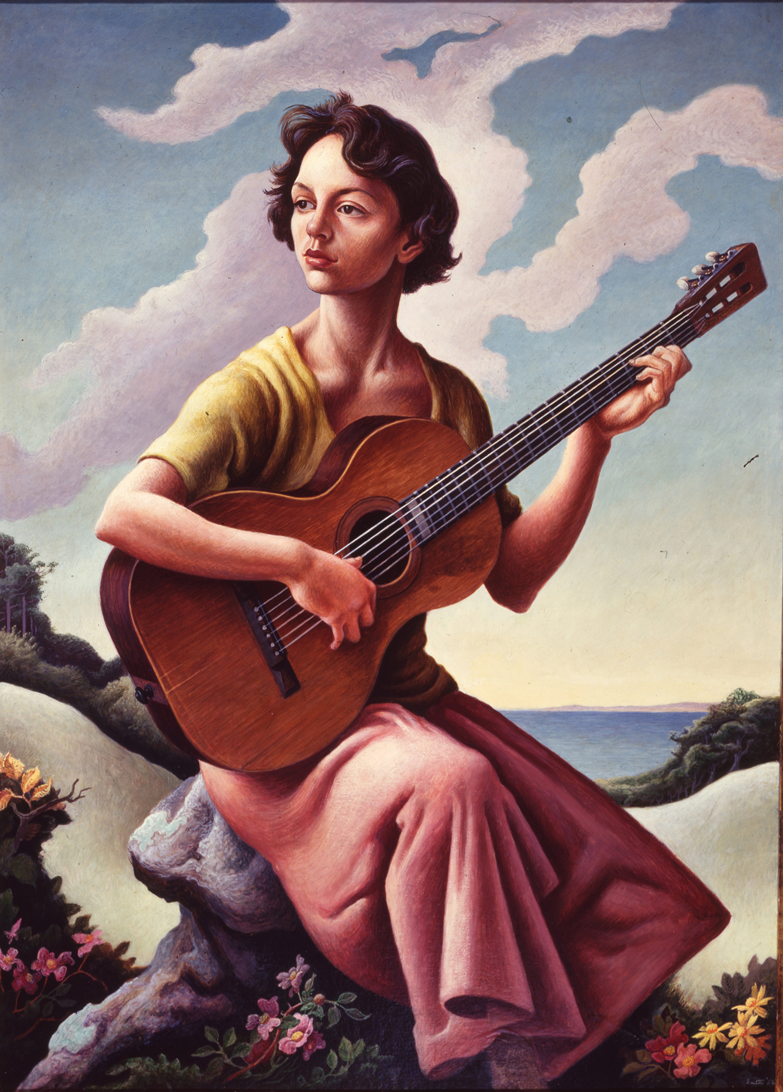Woman sitting on a rock gazing off in the distance playing a guitar