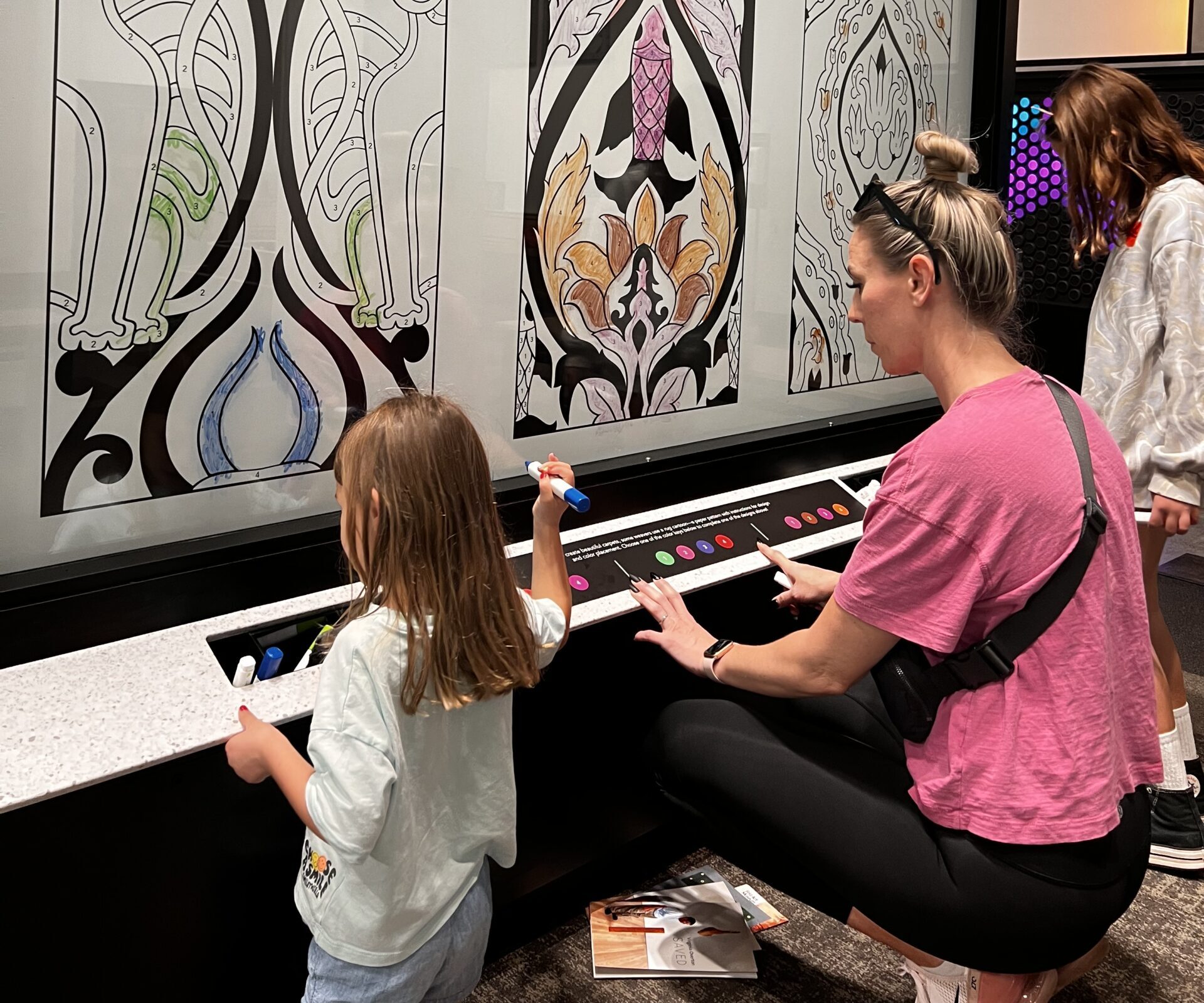 Mom and daughter working together to color an Asian pattern with dry erase markers