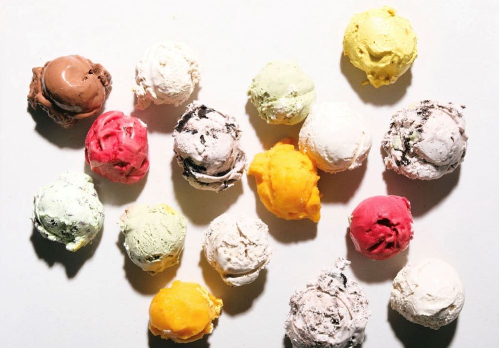 Sixteen scoops of different flavored ice creams