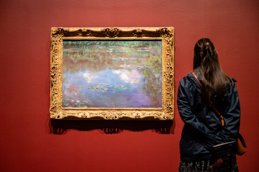 Woman looking at a painting by Claude Monet