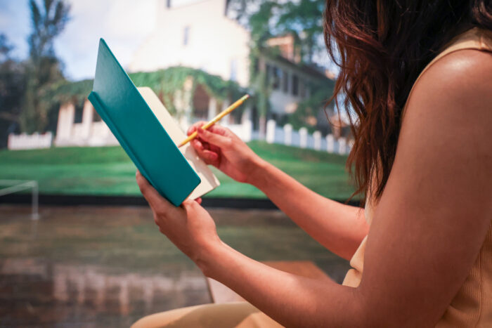 Close up of a young woman sketching in a book