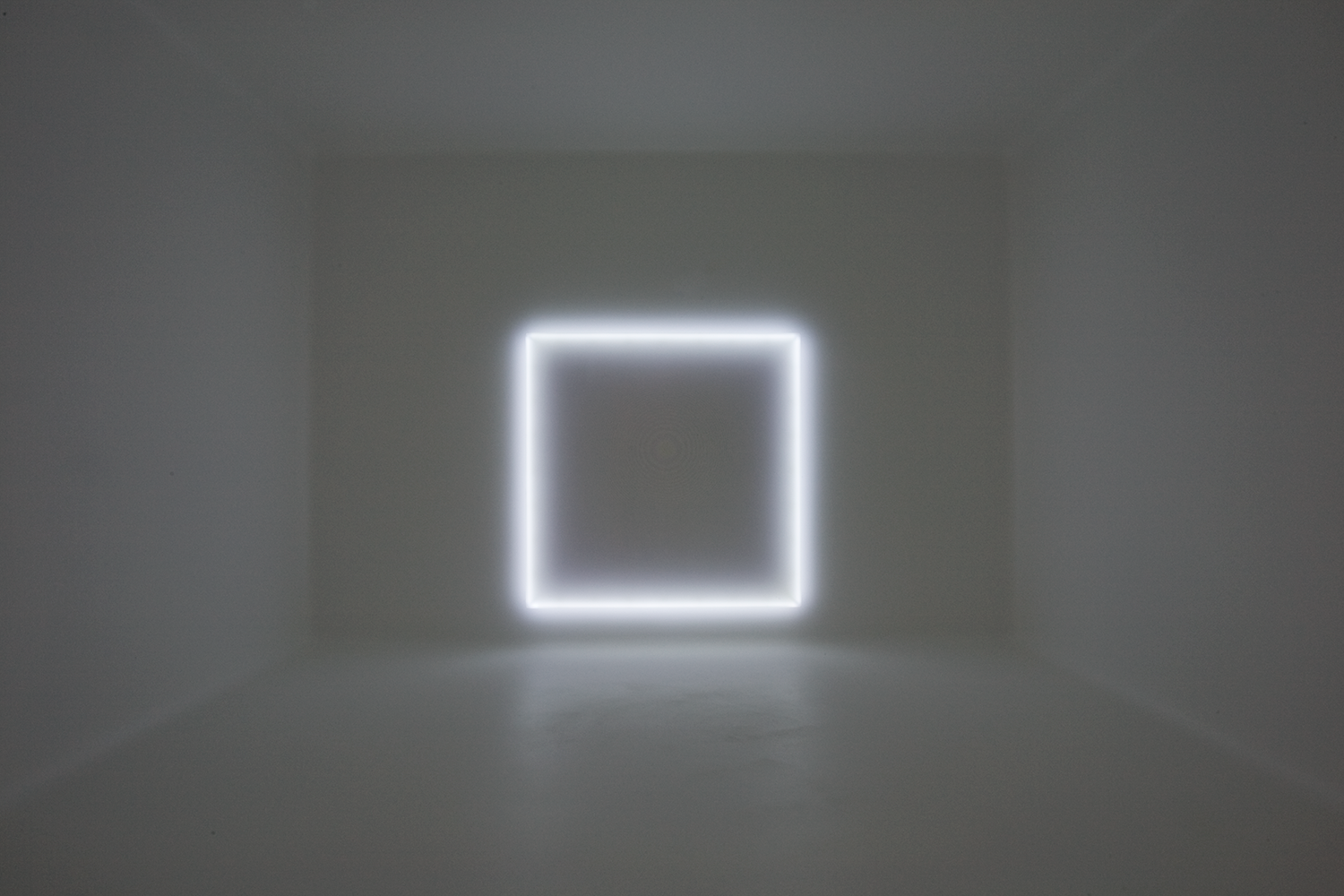 Photo of a white-walled room with a glowing white hallowed square on the far wall.