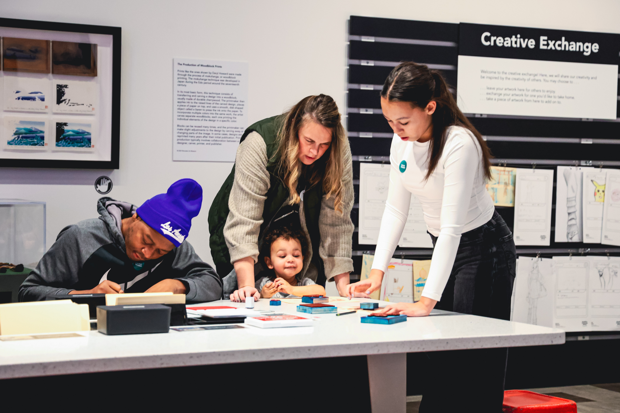 Family working together at an art station in ArtQuest