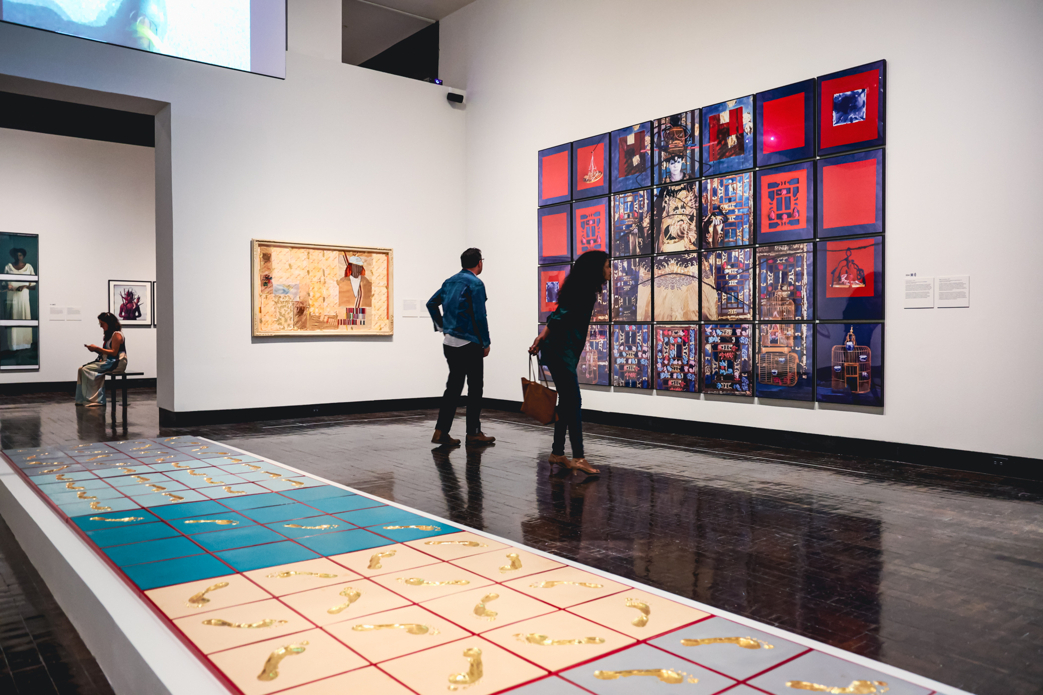 Visitors looking at works of art on view in the Maria Magdalena Compos-Pons exhibition