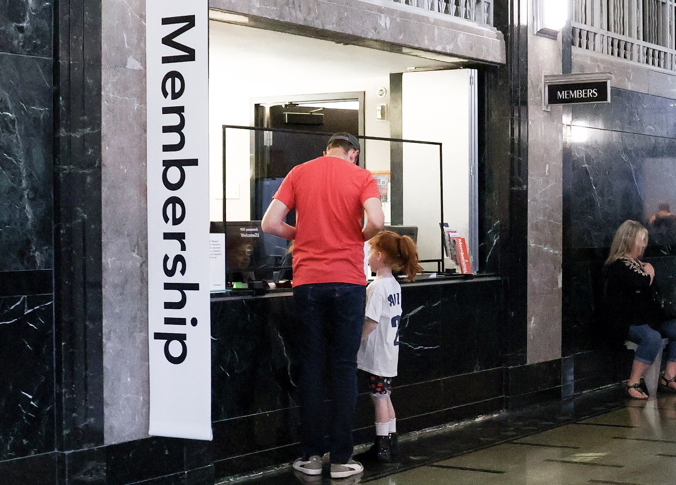 Father and daughter checking in at the membership window