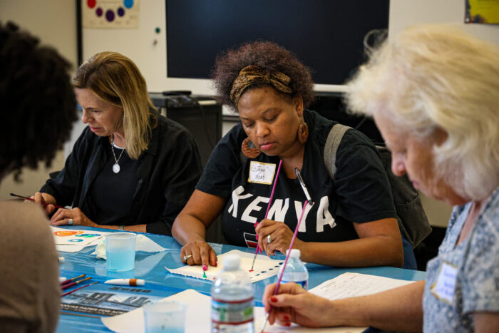 Women at a table, painting, with focus on a black woman