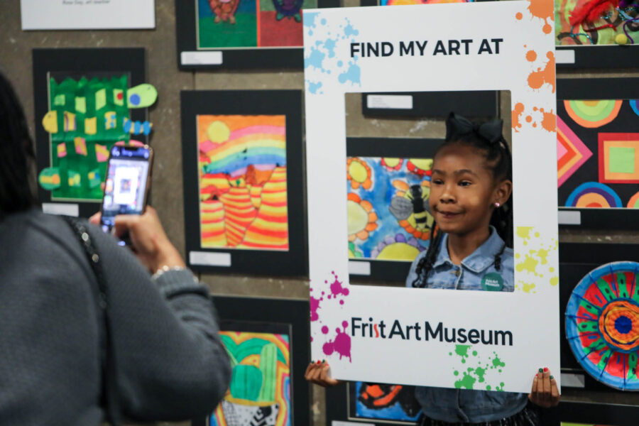 Mom taking photo of daughter at Student Art show
