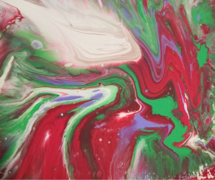 Swirls of red, green white and purple paint on a canvas