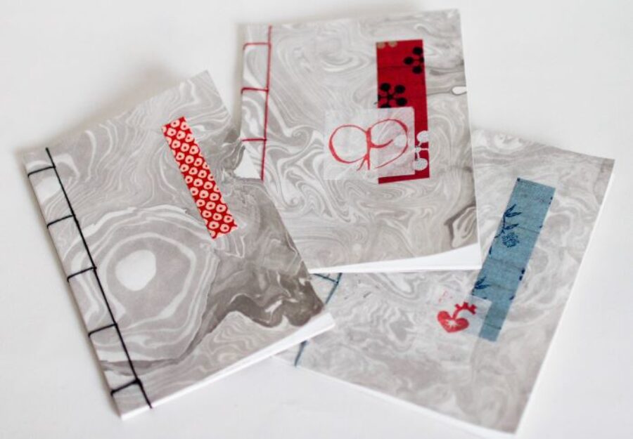 Three book cover featuring swirly gray and white patterns embellished with colorful material pieces.