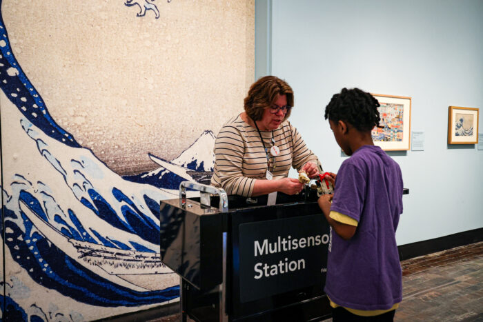 Volunteer working with a boy at the Multisensory Station