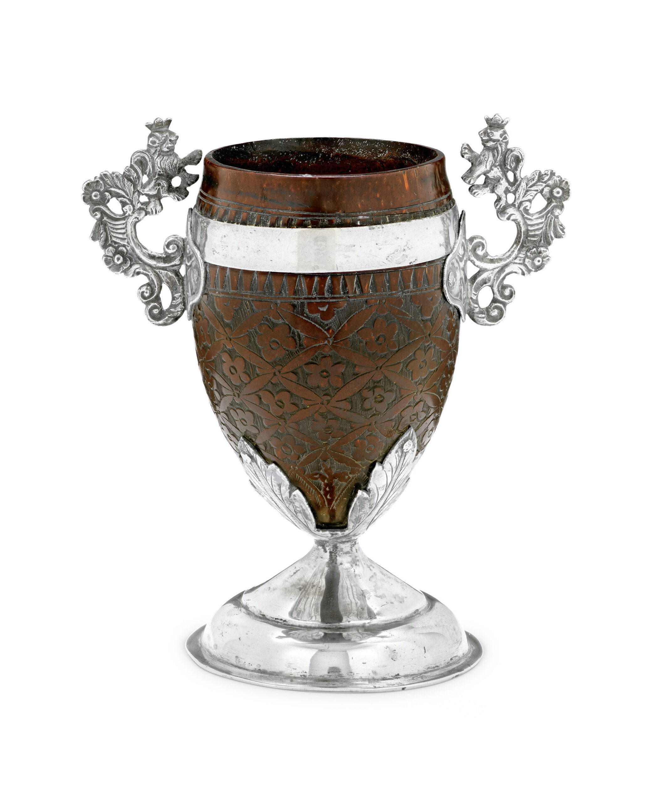 Decorative cup made of carved coconut shell with flowers and a silver base with ornate side decoration
