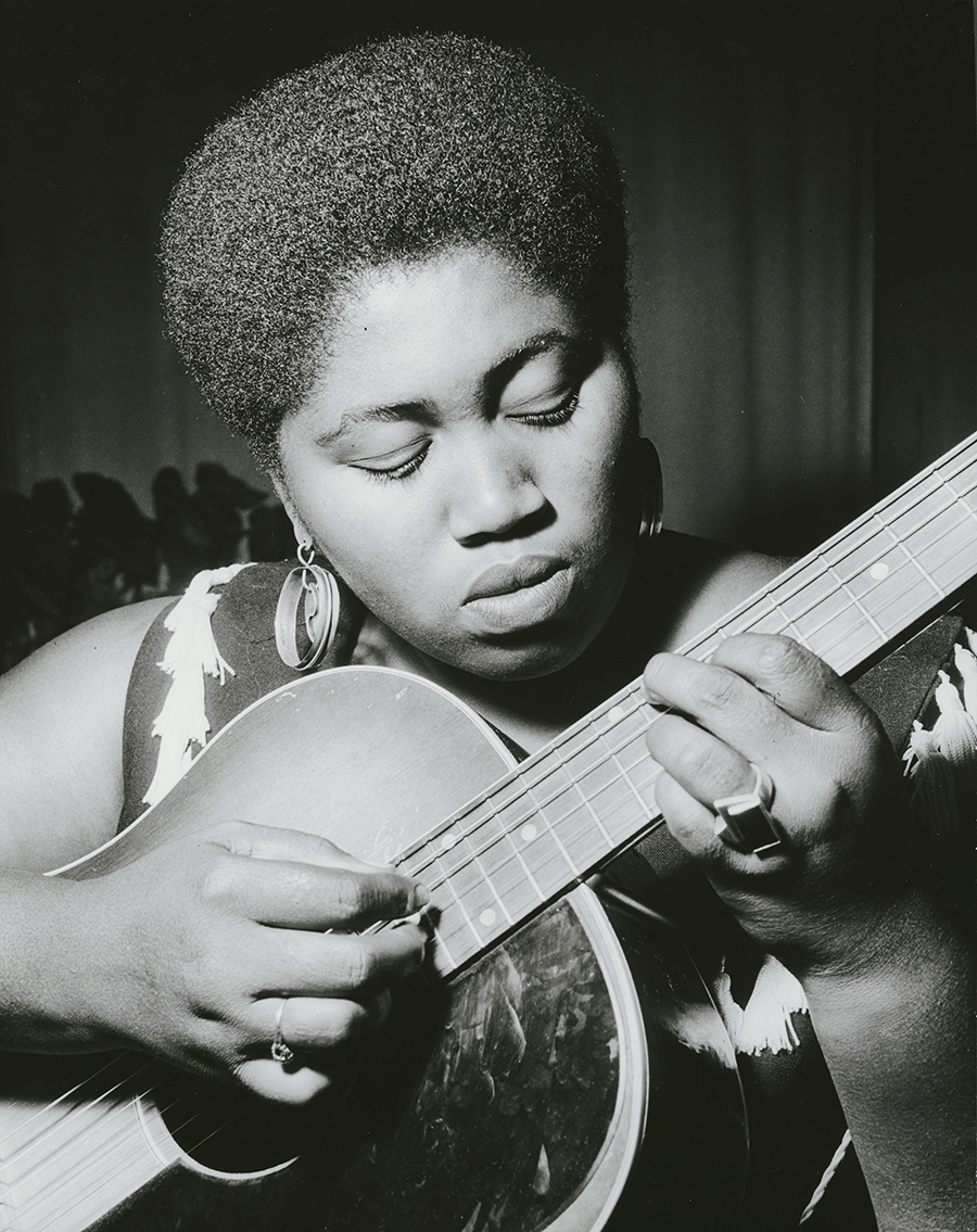 Close up of Odetta Holmes playing the guitar